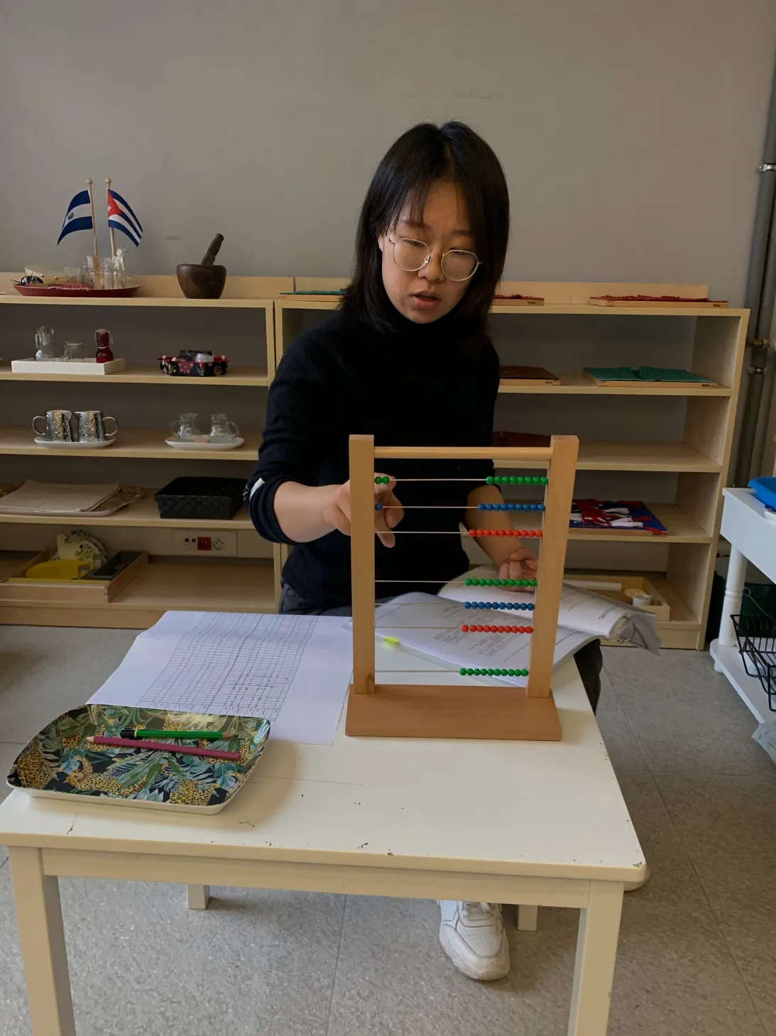 Montessori guide presenting a lesson to children